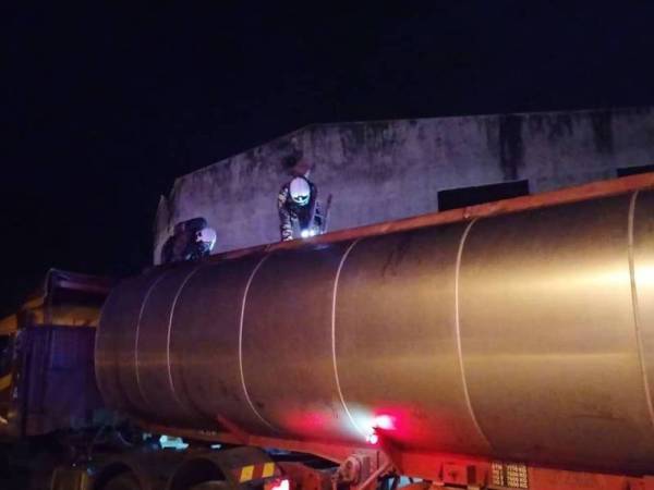 Anggota bomba membantu mengeluarkan pekerja yang pengsan ketika mencuci tangki lori minyak di Kawasan Perindustrian Labis awal pagi tadi.