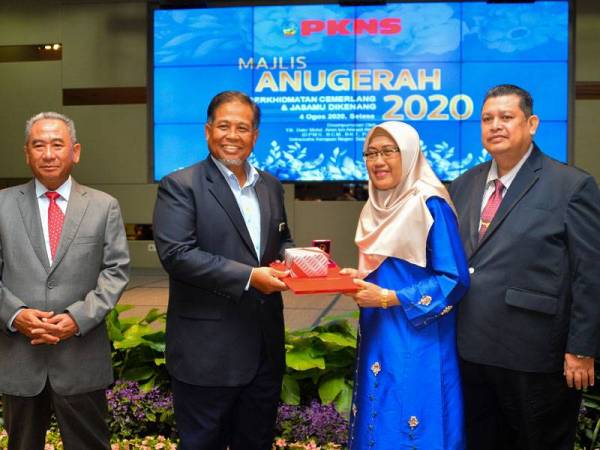 Amin (dua dari kiri) bersama Azizi (kiri) menyampaikan anugerah kepada salah seorang penerima dalam majlis berkenaan.