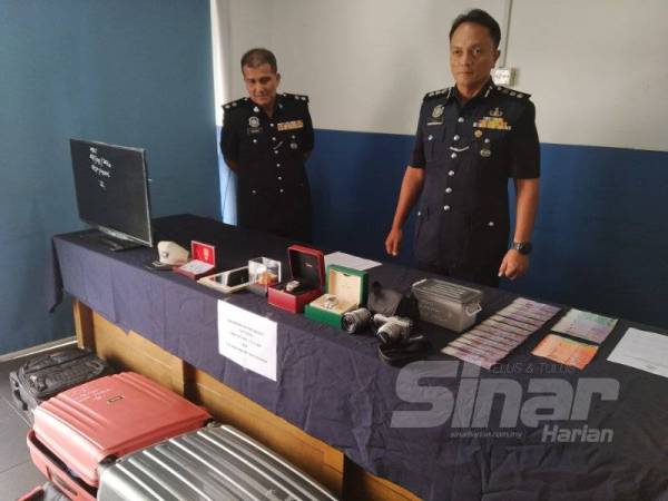 Dzulkhairi (kanan) menunjukkan barang yang dirampas daripada suspek kes pecah rumah pada sidang media di IPD Iskandar Puteri hari ini.
