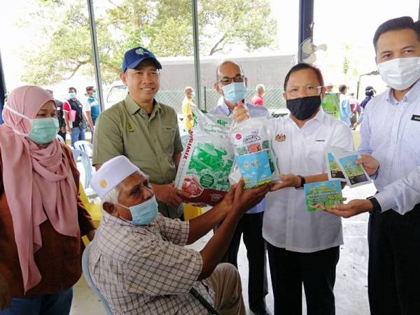 Seorang penduduk Kampung Kuala Slim, Ahmad Shahabudin Abdul Rashid, 78, menerima kit bumi hijau disampaikan Ahmad (dua dari kanan) sempena Penyerahan Bantuan Peruntukan Tahun 2020 bagi daerah Muallim dan Batang Padang serta Perasmian Kursus Pertanian Bandar di Dewan Serbaguna Masjid Kuala Slim di sini hari ini.