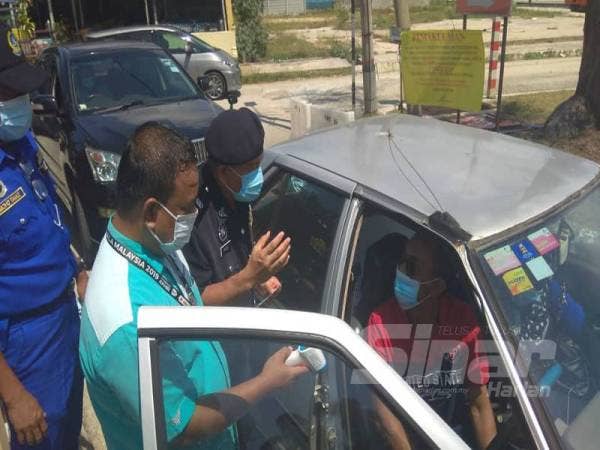 Pemeriksaan suhu dijalankan di setiap laluan masuk sebelum kad nombor diserahkan kepada pengunjung.