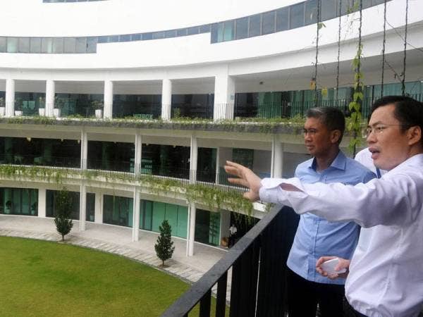 Tengku Zafrul (kiri) diberi penerangan oleh Ketua Pegawai Eksekutif Vitrox Corporation Berhad, Chu Jenn Weng mengenai Kampus Vitrox 2.0 di Persiaran Cassia Selatan hari ini. - Foto Bernama