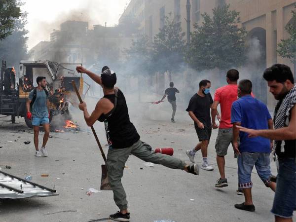 Seorang penunjuk perasaan bertindak membaling batu ke arah anggota keselamatan di Beirut hari ini. - Foto: AFP