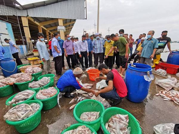 Che Abdullah (tengah) meninjau keadaan di pelabuhan LKIM di Chendering, Kuala Terengganu sempena lawatan kerja di Terengganu semalam.