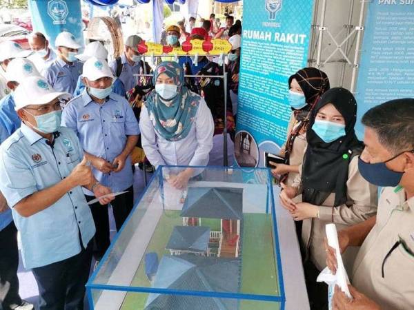 Ronald (kiri) melawat reruai Persatuan Nelayan Negeri pada Mini Karnival Industri Makanan dan Pelancaran Caruman Perkeso Nelayan di Dewan Bunga Raya dekat Changkat Jering, Bukit Gantang hari ini.