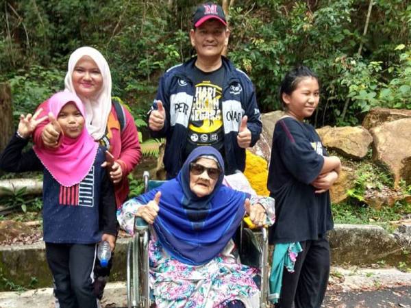 Pengunjung lain turut merakamkan gambar kenangan bersama Mah yang mendaki Gunung Jerai menggunakan kerusi roda.