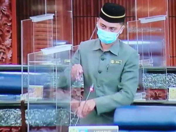 Petugas Parlimen menunjukkan cara menarik dan membetulkan pengadang lutsinar yang dipasang di Dewan Rakyat.