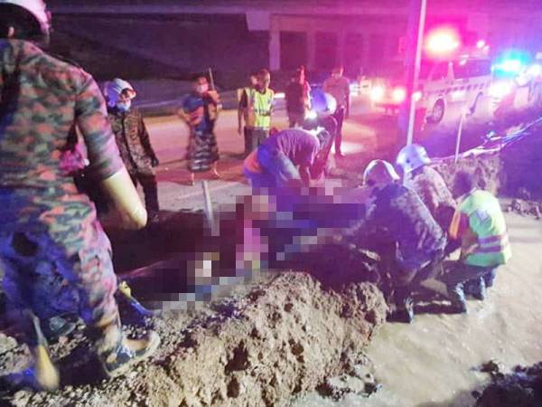 Anggota bomba membantu mengeluarkan dua pekerja yang maut ketika melakukan kerja pemasangan kabel di Jalan Bunga Raya, malam tadi.