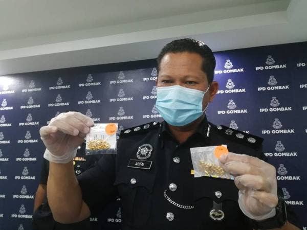 Arifai menunjukkan emas asli (kanan) dan tiruan yang dirampas bagi siasatan.