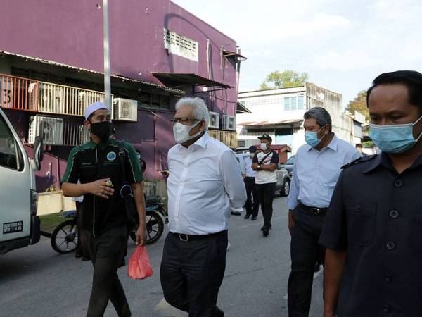 Menteri Dalam Negeri Datuk Seri Hamzah Zainudin bersama Pemilik perniagaan Hot Burger Malaysia Mohd Asri Hamid (kiri) ketika meninjau lokasi perjudian haram yang berlaku di sekitar Bandar Baru Sungai Buloh hari ini.