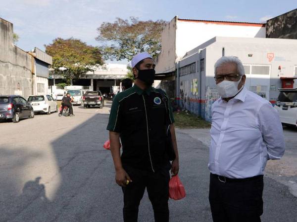 Menteri Dalam Negeri Datuk Seri Hamzah Zainudin bersama Pemilik perniagaan Hot Burger Malaysia Mohd Asri Hamid ketika meninjau lokasi perjudian haram yang berlaku di sekitar Bandar Baru Sungai Buloh hari ini.