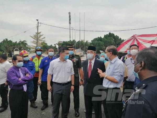 Hang Soon (kanan) mengiringi Yang Dipertua Negeri, Tun Mohd Ali Mohd Rustam melawat kawasan sekolah (SRJKC) Malim yang mengalami kerosakan akibat ribut, di sini, hari ini.