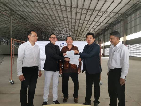 Pak Leong Cha (dua dari kanan) bertukar dokumen perjanjian kerjasama korporat dengan Han Keat (dua dari kiri) dengan diperhatikan Choon Hwa (tengah) di Sendayan hari ini.