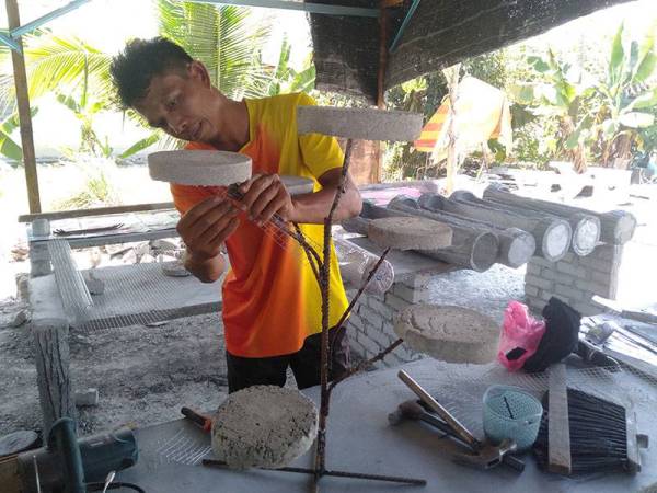 Norhisham sedang menghasilkan rak pasu bertingkat di bengkel Nicron Riemal Resources di Seksyen 29, Shah Alam, Selangor.