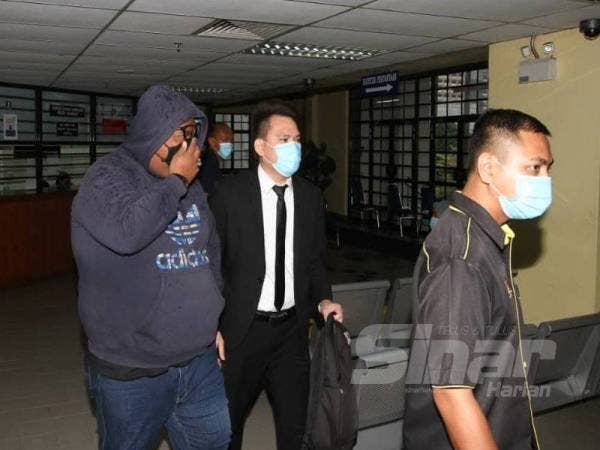 Mohd Yusri (kiri) dibawa ke Mahkamah Sesyen Johor Bahru hari ini untuk dibicarakan atas dakwaan meminta wang suapan.