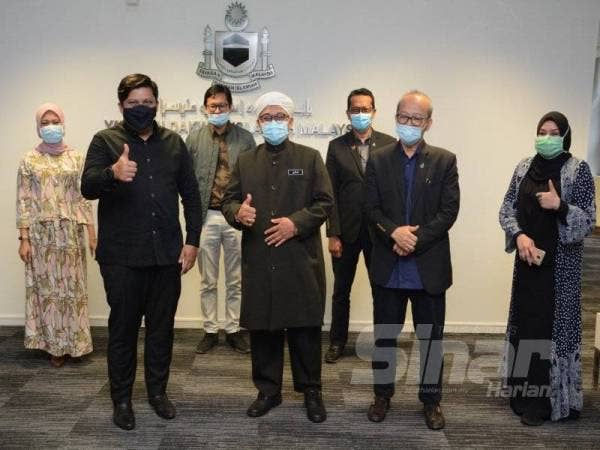 Namanzee (depan, kiri) Nasrudin (depan, dua dari kiri) bergambar kenangan bersama barisan pengurusan stesen penyiaran TV Alhijrah dan Yadim di ibu pejabat Yadim, Putrajaya semalam.