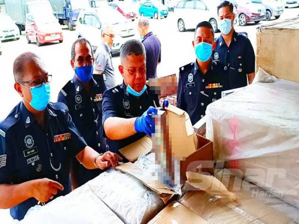 Ab Rashid (tiga dari kiri) memeriksa rokok-rokok yang diseludup dan dipercayai untuk pasaran luar Tumpat.