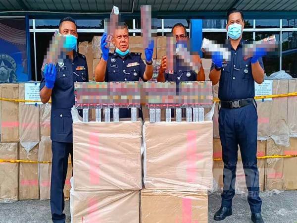 Ab Rashid (dua dari kiri) bersama pegawainya menunjukkan rokok putih yang berjaya dirampas oleh polis selepas menahan sebuah lori di Simpang Empat Kampung Besut.