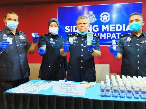 Ab Rashid (dua dari kanan) menunjukkan wang tunai, ubat batuk dan pil jenis nitrazepam yang berjaya dirampas.