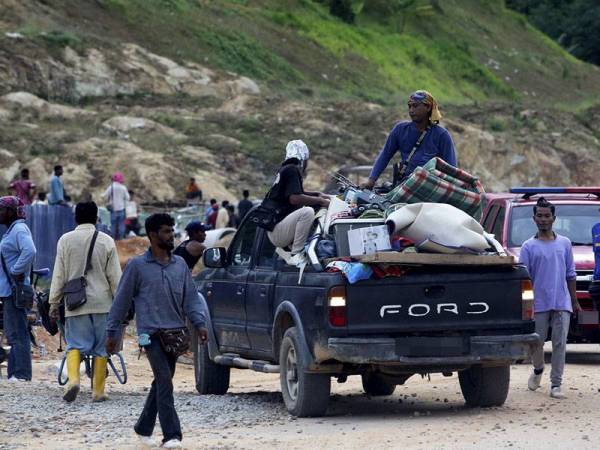 Pekerja kontrak binaan dilihat sibuk memindahkan barangan yang sempat diselamatkan ekoran rumah kongsi yang didiami mereka musnah akibat kebakaran di Jalan Labu LBJ Taman Gadong Jaya hari ini. Foto: Bernama