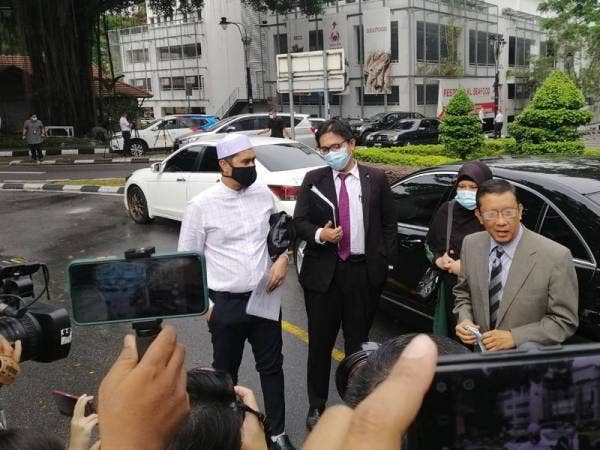 Mohd Asri (kiri) yang ditemani peguamnya tiba di Bukit Aman, Kuala Lumpur kira-kira jam 10.25 pagi tadi.