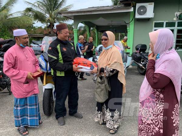 Norhani (dua dari kanan) menyampaikan cenderahati kepada Ustaz Hanafi.