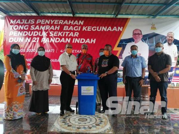Izham (tiga dari kiri) pada majlis penyerahan tong sampah yang disumbangkan oleh KDEBWM semalam.