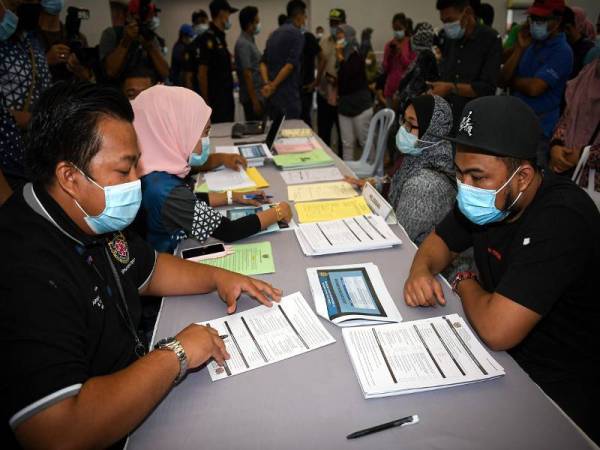 Penduduk kawasan Sungai Buloh mendengar penerangan daripada kakitangan Majlis Bandaraya Shah Alam (MBSA) untuk mendaftar lesen perniagaan pada Program Penyusunan Semula Peniaga dan Penjaja Bandar Baru Sungai Buloh di Dewan Meranti hari ini. - Foto Bernama