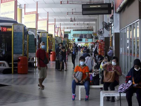 Orang ramai yang menunggu perkhidmatan bas dilihat mematuhi peraturan yang telah ditetapkan kerajaan iaitu mengenakan pelitup muka sebagai langkah pencegahan penularan COVID-19 ketika di hentian bas Terminal One hari ini. - Foto Bernama