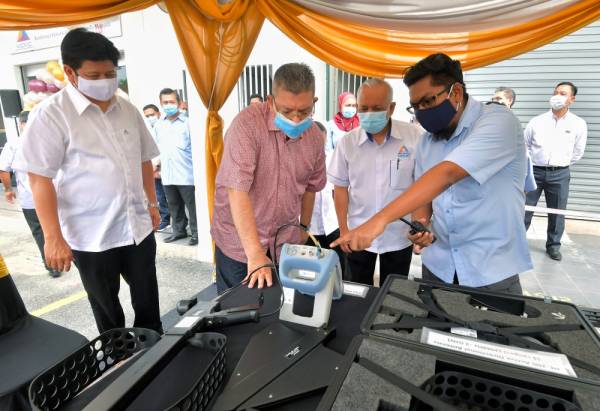 Saifuddin (dua dari kiri) melihat pameran ketika hadir pada perasmian pejabat SKMM Pahang di Kuantan hari ini. - Foto Bernama