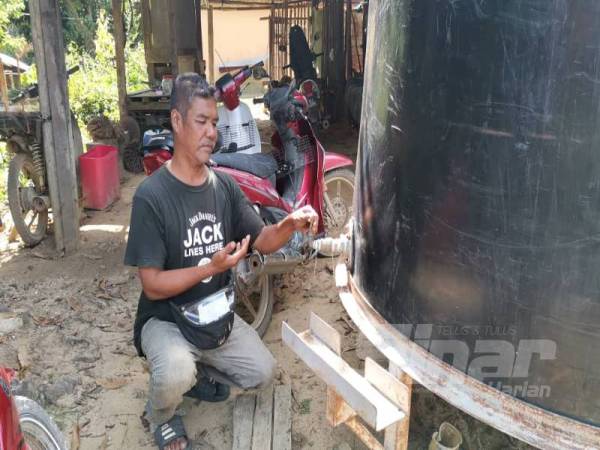 Muzalan dolah, 47, menunjukkan tangki air kosong selepas pam yang menyedut air bawah tanah rosak.