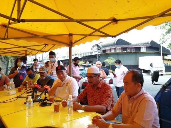Annuar (tengah) ditemui selepas menyampaikan lesen penjaja kepada peniaga di Batu Muda hari ini.