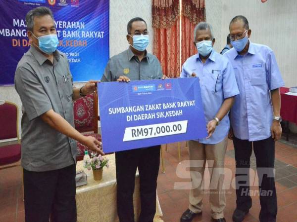 Rosman (dua dari kanan) menyerahkan replika cek kepada Muhammad Sanusi (dua dari kiri) sempena Majlis Penyerahan Sumbangan Zakat Bank Rakyat di daerah Sik di Sik Inn hari ini. 