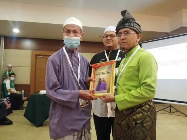 Ahmad Bilal (tengah) mengiringi Ketua Pemuda Pas Pusat, Ir Khairil Nizam Khirudin menyampaikan anugerah khas kepada salah seorang penerima pada
Muktamar Dewan Pemuda Pas Melaka Ke-45 di Bukit Katil, Melaka hari ini.