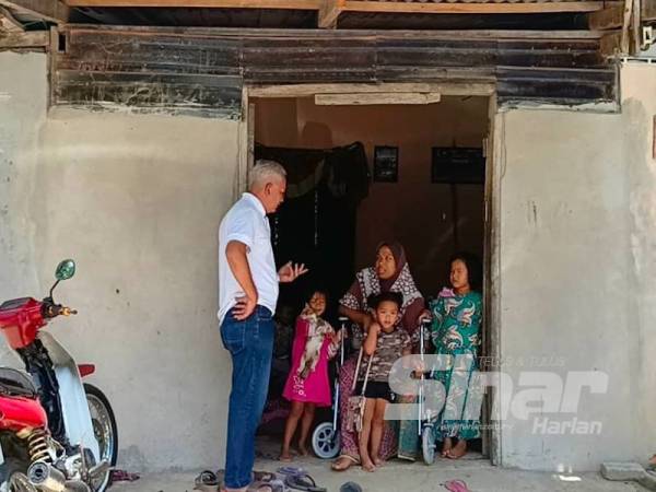 Nur Azipah dan anak-anaknya menerima kunjungan dari Pertubuhan Cakna Bantu Rakyat Pasir Puteh, Mohd Nizam (kiri) di rumahnya di Kampung Jeram Pasu.