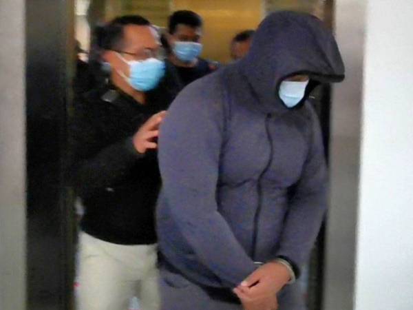 Tertuduh (kanan) ketika dihadapkan di Mahkamah Sesyen hari ini atas pertuduhan menerima rasuah.