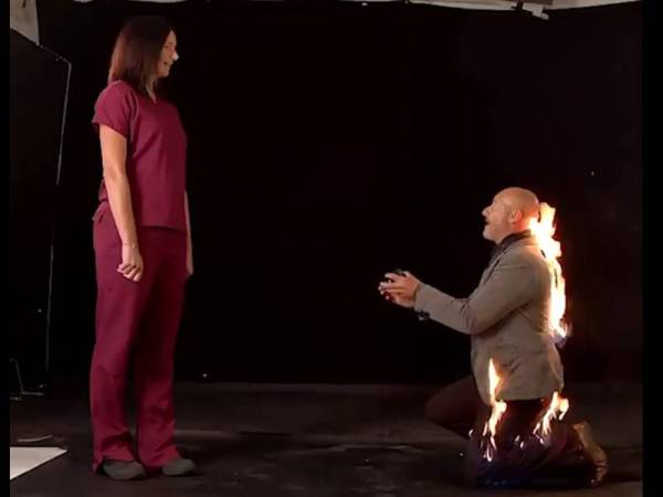 Riky Ash (kanan) melutut untuk melamar kekasihnya dalam keadaan bahagian belakangnya sedang terbakar.