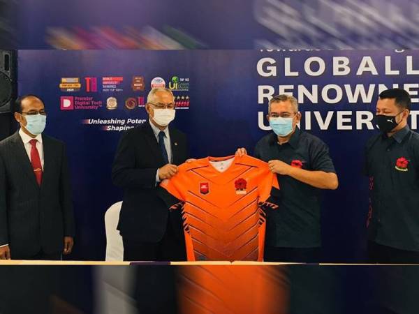 Shahrul Zaman (dua kanan) menyerahkan jersi skuad ragbi negara kepada Naib Canselor UiTM, Profesor Emeritus Datuk Ir Dr Mohd Azraai Kassim selepas majlis berkenaan.