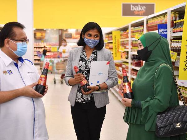 Pengarah Urusan FA International Trade Sdn Bhd, Atie Ahmad (kanan) memberi penerangan kepada Alexander dan Sushmita Paul mengenai produk keluaran syarikatnya di Tesco Extra Mutiara Damansara, Petaling Jaya pada Sabtu lalu.