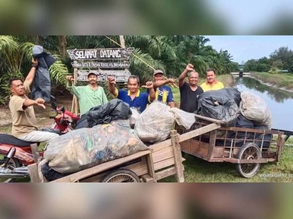 Sukarelawan bergambar bersama sampah dari parit yang berjaya dibersihkan.
