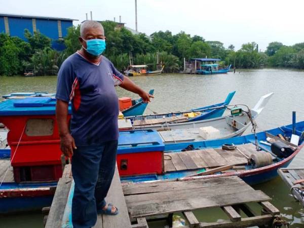 Osman menunjukkan botnya yang tersadai di Kuala Sala di sini hari ini.