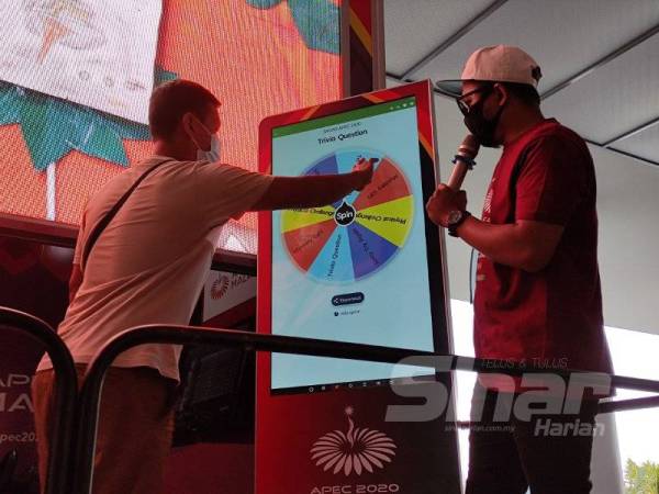Orang ramai mencuba permainan Wheel of Fortune yang dikendalikan Skuad APEC 2020.