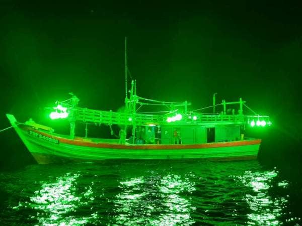 Seorang tekong serta tiga kru warga tempatan atas sebuah bot pukat tunda kelas C ditahan oleh APMM. - Foto ihsan APMM