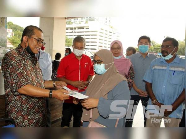 Mohamed Khaled (kiri) hadir pada Program Bantuan Makanan Yayasan Pasir Gudang hari ini.