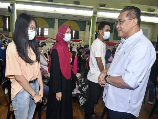 Menteri di Jabatan Perdana Menteri (Parlimen dan Undang-Undang), Datuk Takiyuddin Hassan (kanan) beramah mesra bersama penuntut Institut Pendidikan Guru (IPG) Kampus Sultan Mizan pada Majlis Skim Bantuan Pelajar Parlimen Kota Bharu di Dewan Jubli Perak, Majlis Perbandaran Kota Bharu Bandar Raya Islam (MPKB-BRI) hari ini. - Foto Bernama