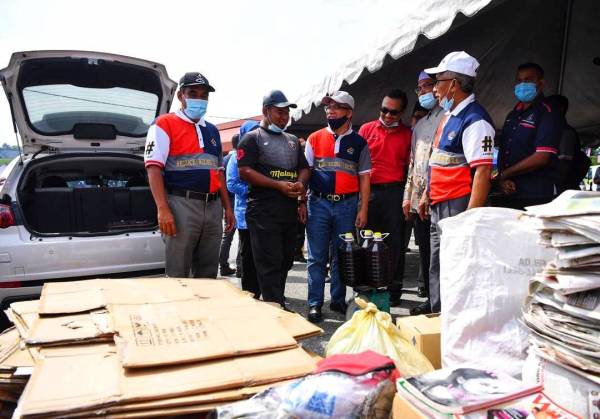 Ismail (kanan) dan Abd Rahim (kiri) bersama barangan kitar semula yang terkumpul sempena program Jangan Gunalah Plastik Sekali Guna dan pelancaran 'Trash to Cash' peringkat daerah Maran di Dewan Jubli Perak Sultan Haji Ahmad Shah hari ini.