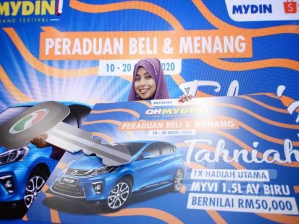 Rashidah bersama replika hadiah utama berupa sebuah Perodua Myvi yang dimenanginya menerusi Peraduan Beli & Menang OHMYDIN! Buy & Win MYDIN@Shopee. - Foto:ROSLI TALIB