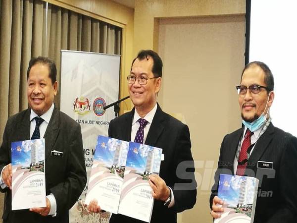 Nik Azman (tengah) menunjukkan buku Laporan Audit Negara Tahun 2019 pada sidang media di sini hari ini.