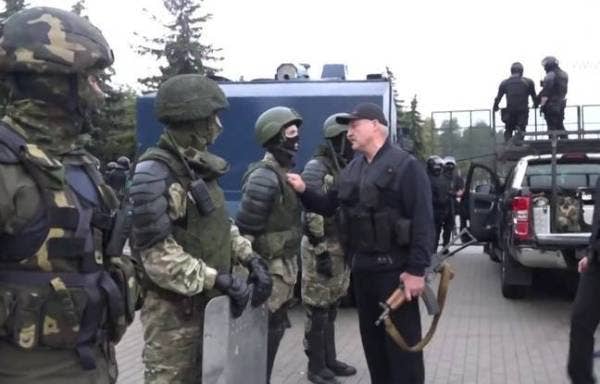 Presiden Belarus, Alexander Lukashenko (kanan) memakai baju kalis peluru dan memegang senapang Kalashnikov di Minsk pada 23 Ogos lalu. - AFP