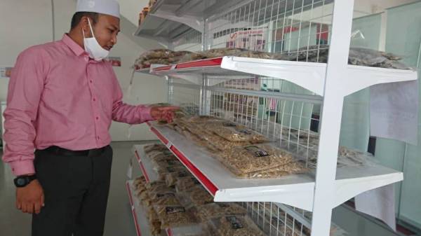 Mod Farid menunjukkan produk Ikan Bilis Pangkor yang dijual di Ukhwah Harmony Mart. 